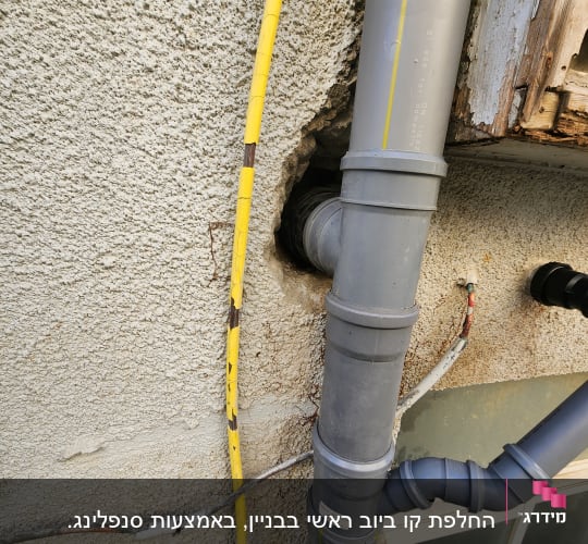 צינור אפור מחובר לקיר עם כבל צהוב
